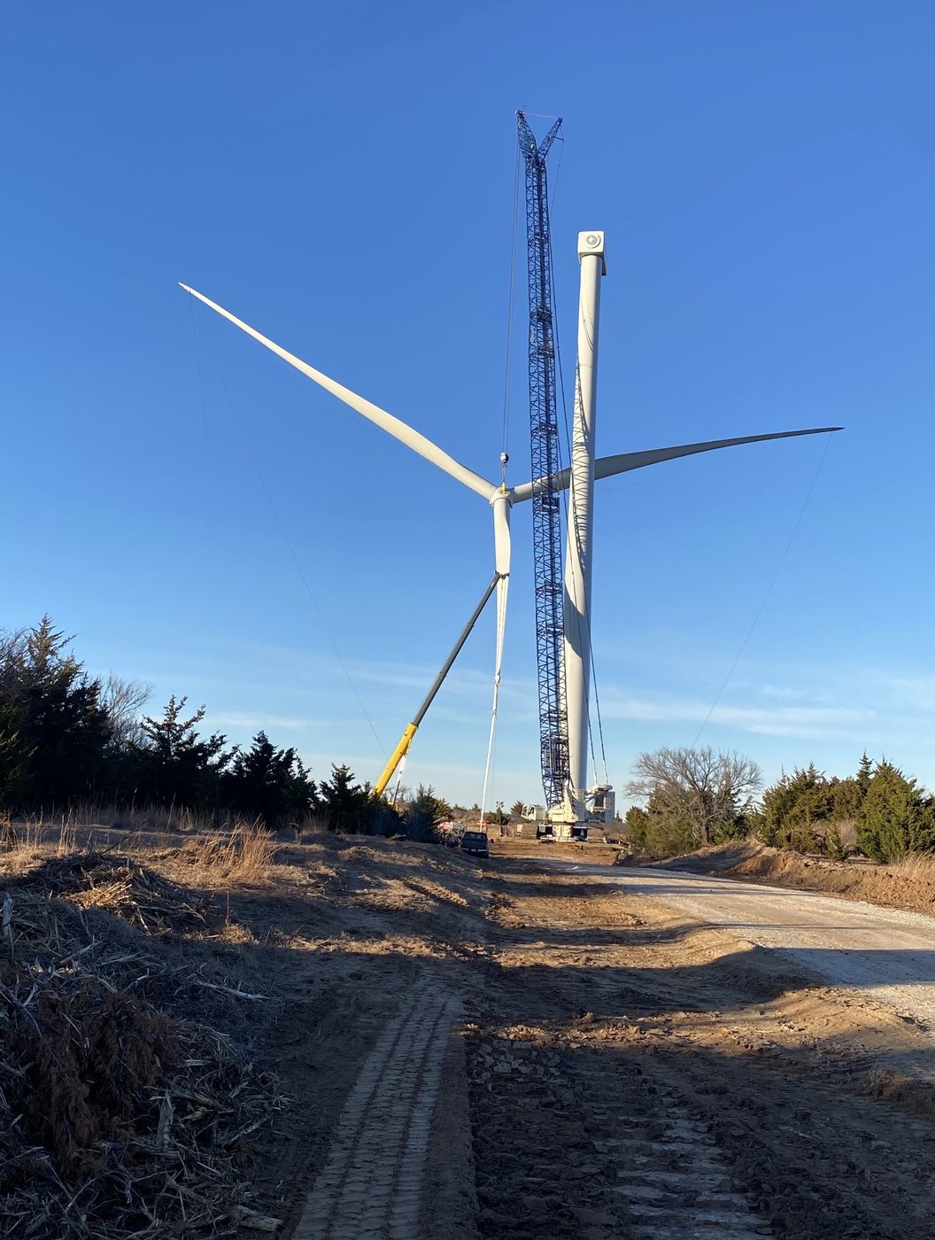 Crawler crane next to completed wind turbine